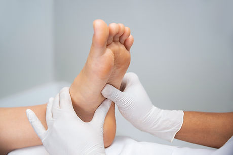 Gloved hands performing foot examination